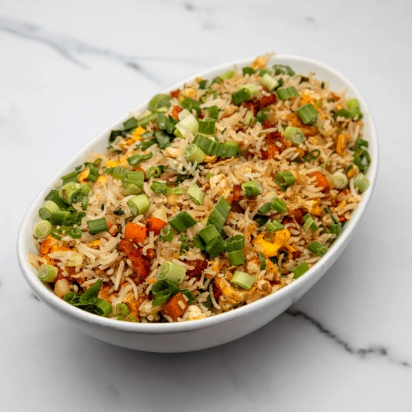 Mintt Indian Cuisine's fried rice with chicken, egg, carrots, and green onions in a white bowl.