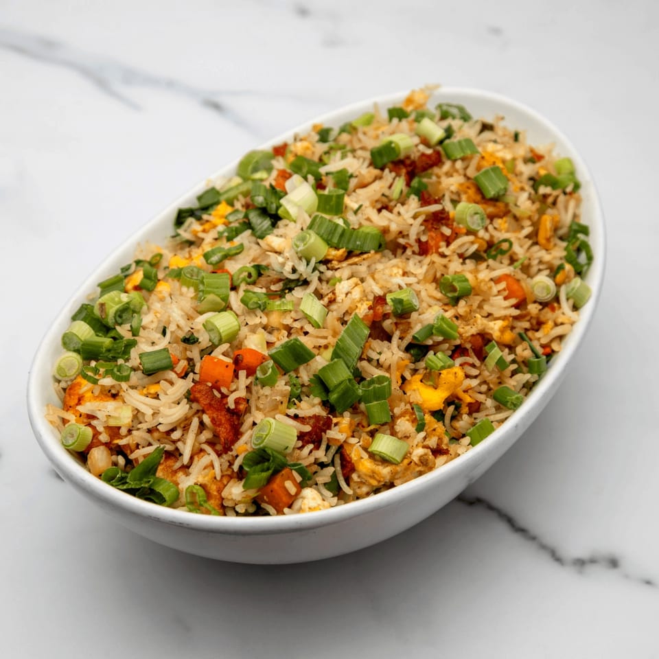 Mintt Indian Cuisine's fried rice with chicken, egg, carrots, and green onions in a white bowl.