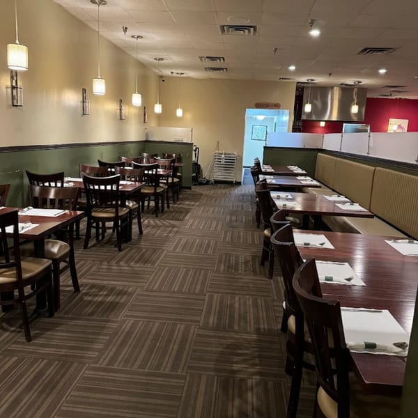 Interior of Mintt Indian Cuisine restaurant with empty tables, chairs, and booth seating.